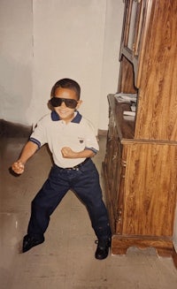 a young boy wearing sunglasses in a room